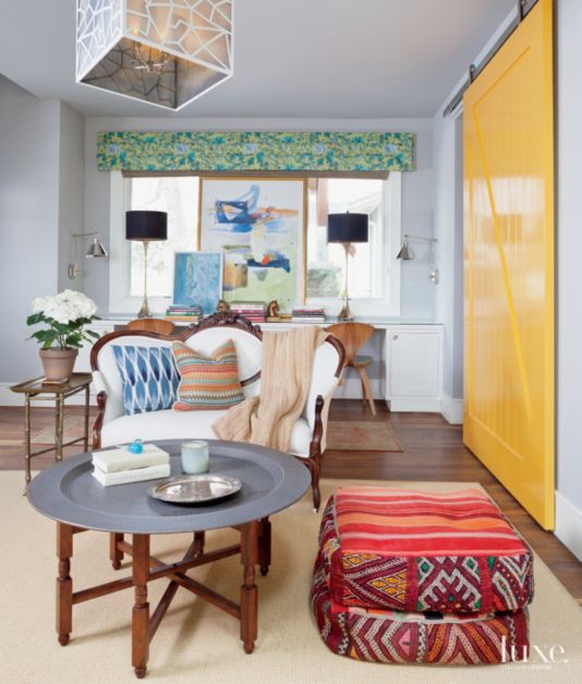 yellow lacquered barn door separates dining area in eclectic and colorful space
