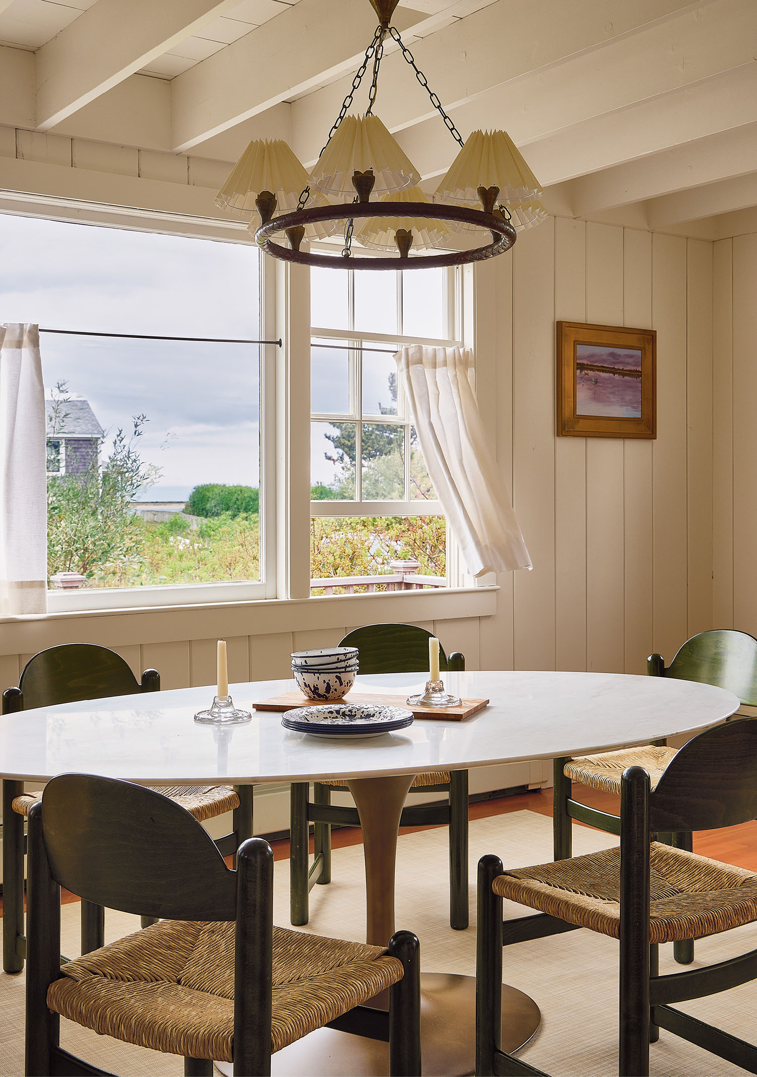 A wooden table surrounded by four chairs in a well-lit dining area.
