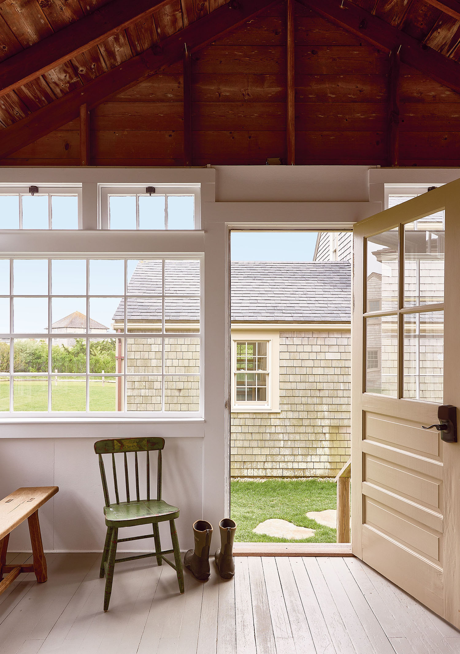A porch featuring a wooden bench and a door leading to the outside.