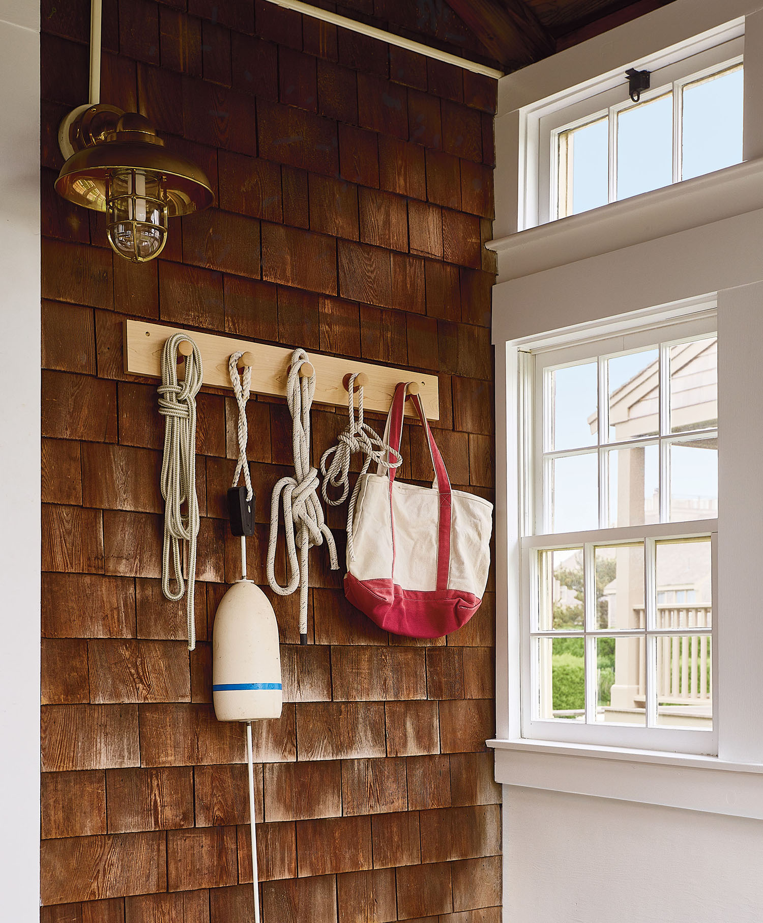 A wooden bench with a bag hanging on the wall above it, set in a simple, uncluttered environment.