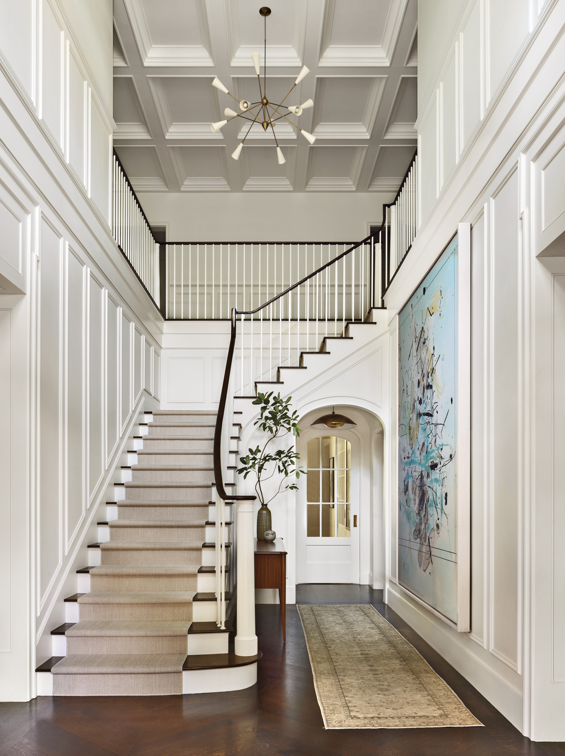 A large staircase in a home, featuring white walls and a clean, modern design