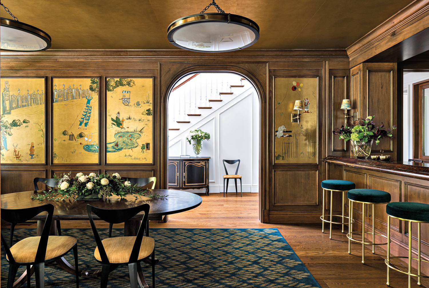 Elegant dining room showcasing gold and blue walls alongside a sophisticated gold and blue bar for a refined look.