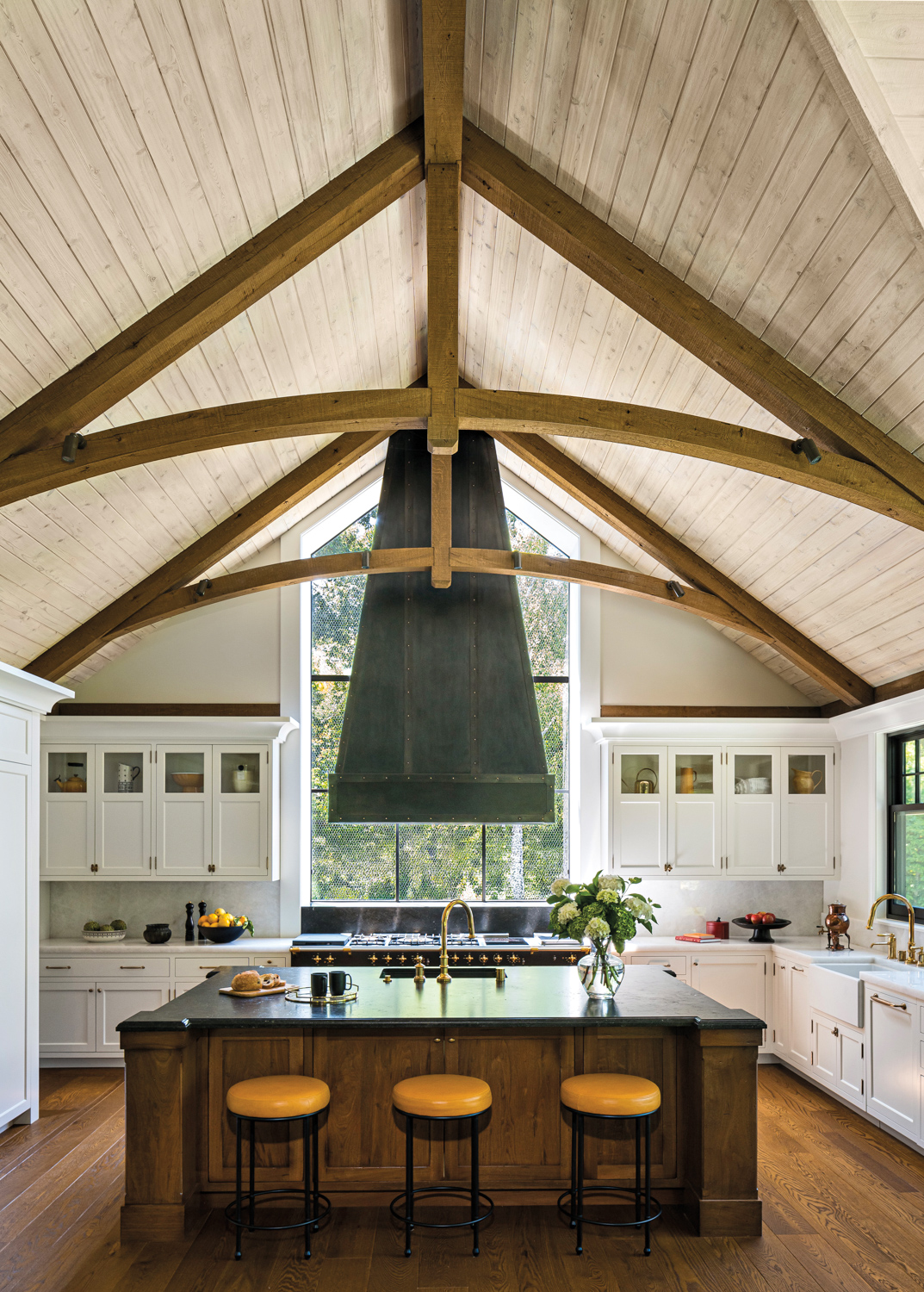 A modern kitchen featuring a center island and a large window that lets in natural light.
