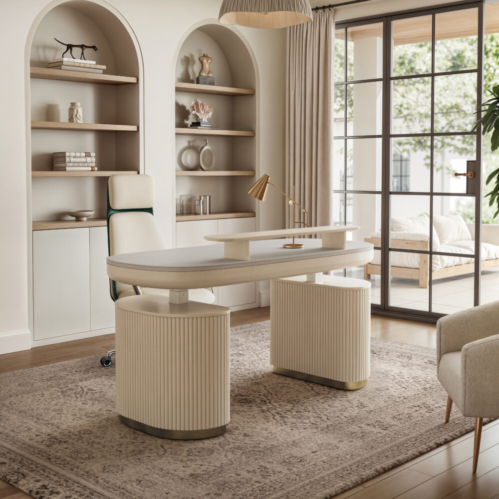 Modern home office with a large white desk, gold lamp, office chair, bookshelves, and floor-to-ceiling windows overlooking a patio. Neutral tones and minimal decor.